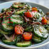A chilled bowl of Refreshing Crunchy Cucumber Salad featuring crisp cucumbers, fresh dill, and cherry tomatoes ready to serve.