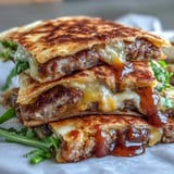 Golden-brown Cheesy Griddled Smashburger Quesadillas rest on a cutting board, showcasing melted cheddar and American cheese oozing from crispy edges. 