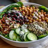Colorful vegan Rainbow Salad Bowl topped with seeds and fresh herbs, ready for lunch.
