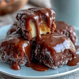 Candy apple slices dipped in creamy caramel and drizzled with dark chocolate, garnished with chopped nuts for a crunchy finish.