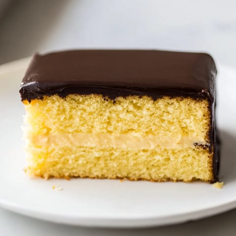 Moist yellow cake layers filled with vanilla cream and topped with glistening ganache, the Ho Ho Cake.