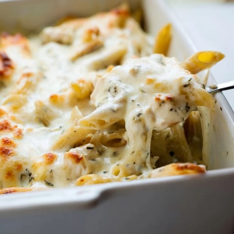 Freshly baked Chicken Ranch Pasta Bake with golden, bubbly mozzarella and creamy ranch sauce, served in a casserole dish.