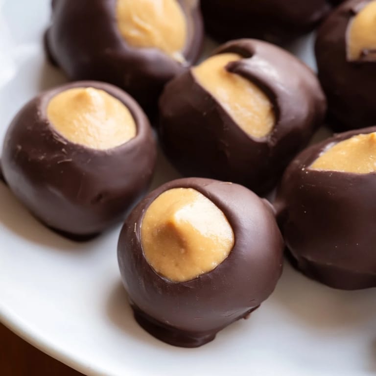 Homemade buckeyes, a classic no-bake dessert, sit ready to eat on a lined baking sheet for the holidays.