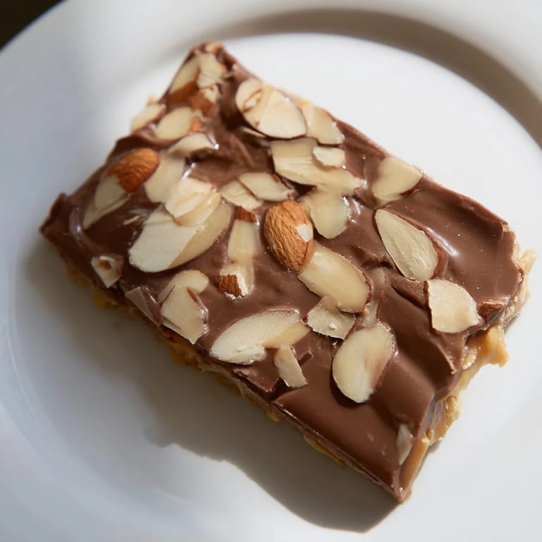 Close-up of freshly made English toffee, showing the crackly, buttery toffee base and almond topping.