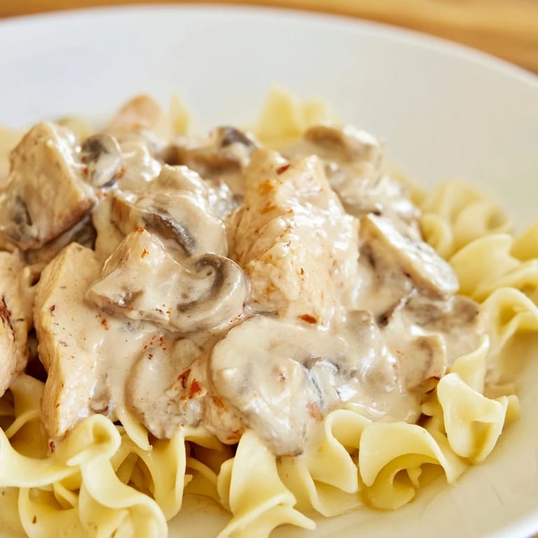 Hearty Chicken and Mushroom Stroganoff garnished with fresh parsley, paired with a crisp green salad for a comforting weeknight meal.