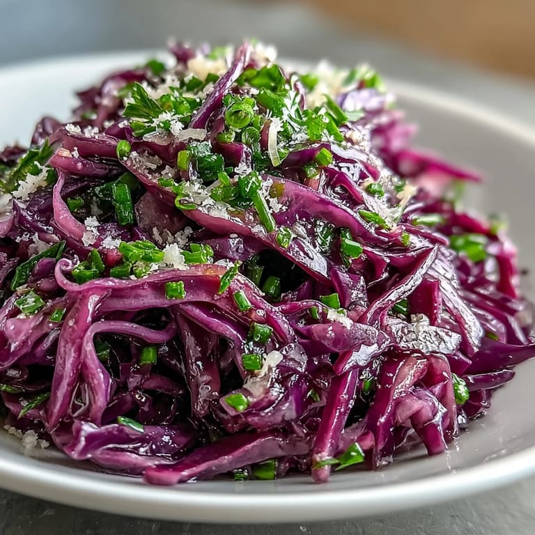 Vibrant bowl of Red Cabbage Coleslaw With Apple and Parmesan featuring crisp shredded cabbage, julienned apple, and green onions.