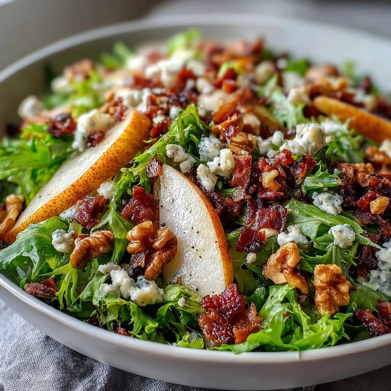 A close-up of a Frisée Pear Blue Cheese Bowl featuring crunchy walnuts and glistening olive oil dressing, ready to serve at a dinner party.