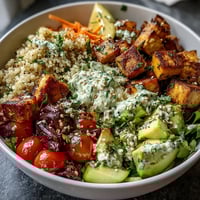 Colorful Customizable Grain Bowl with roasted sweet potato, avocado, and a generous drizzle of creamy lemon-tahini dressing.